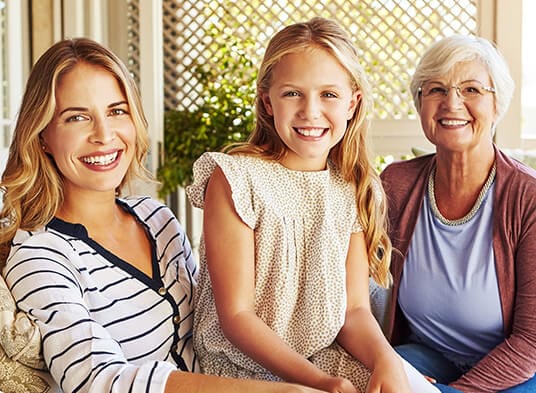 Mother, daughter, and granddaughter smiling together