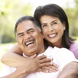 Smiling couple with dental implants in Fairfax