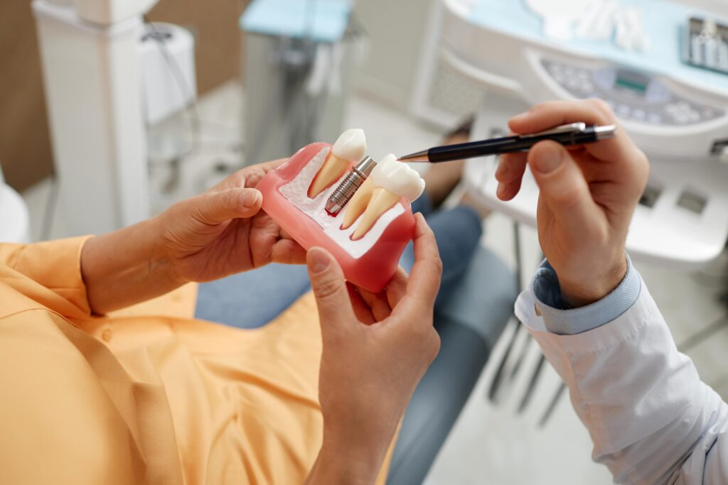 Dentist pointing to model of dental implant